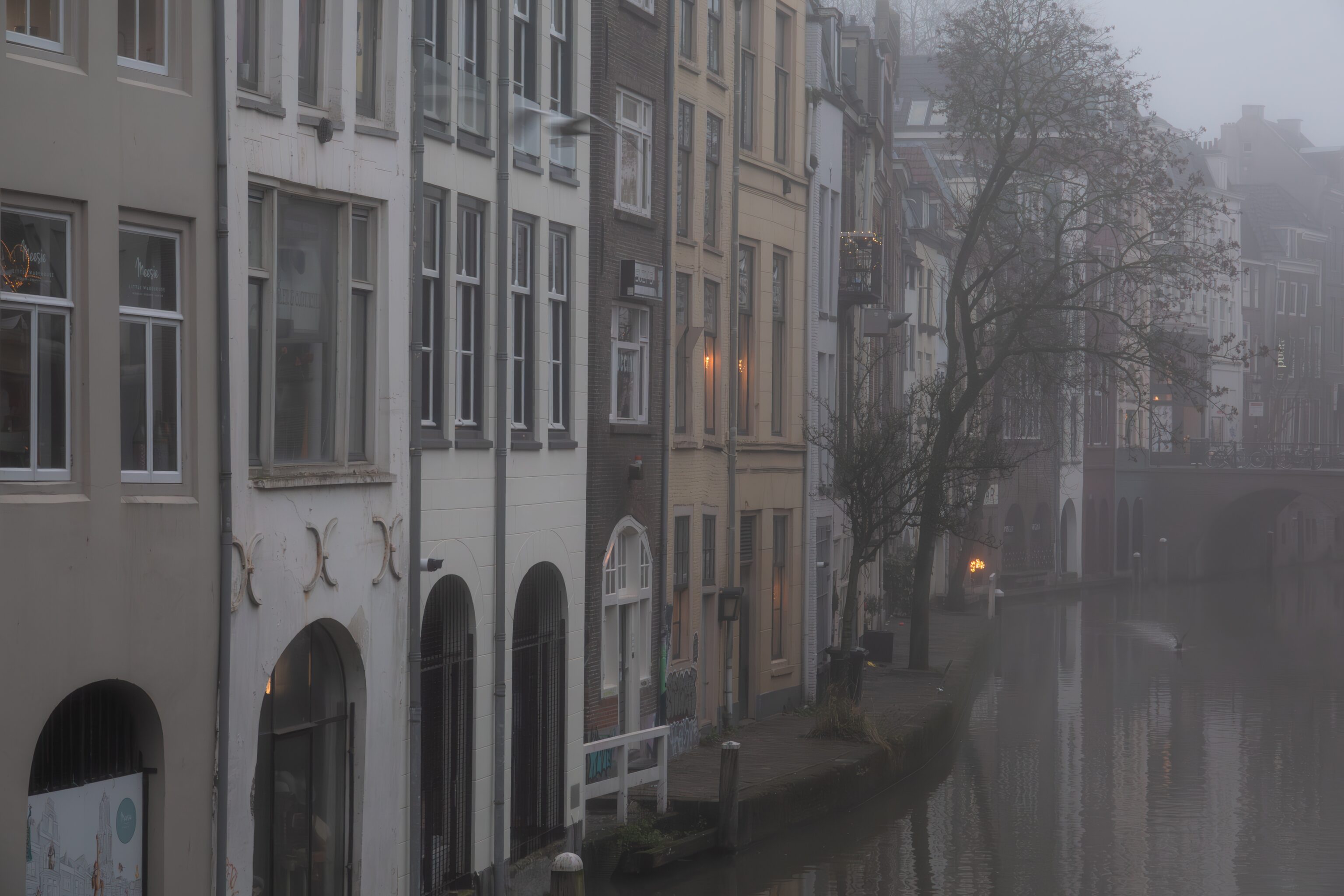 Huizen aan de Oudegracht in de nevel